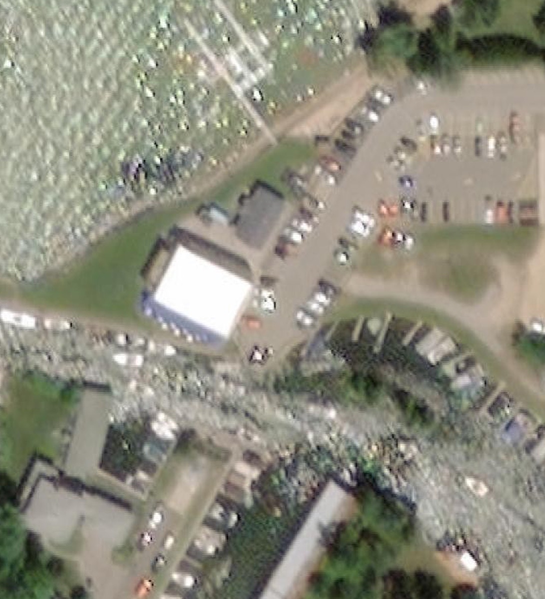 Aerial view of the same Dockside site, summer 2020: a smaller dock complex with one to two lakefront fingers and few boats — an in-season capture with the parking lot full.